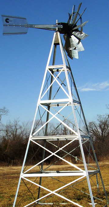 Close up of a silver 4-legged windmill head against a blue sky.