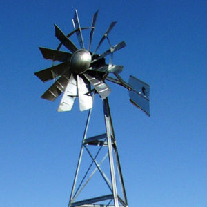A windmill head against a blue sky.