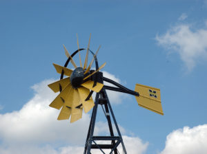 A yellow windmill head against a background of sky.
