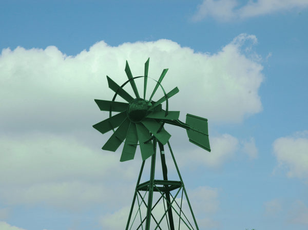 A green windmill on blue sky background.