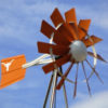 A orange and white windmill with a Texas Longhorns logo on the tail fin.