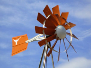 A orange and white windmill with a Texas Longhorns logo on the tail fin.