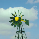 A green and yellow windmill on a blue sky.