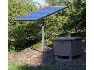 A solar panel with tan aeration kit next to shrubs.