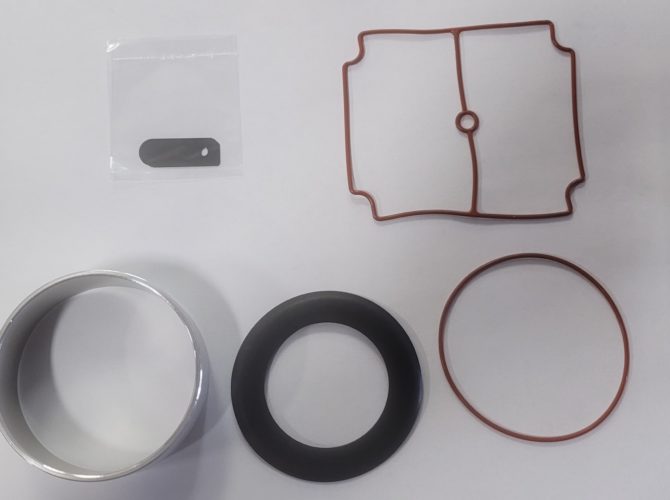 Matala Replacement 1/4 HP Rocking Piston Maintenance Kit. Two round gaskets. One thin and red, one thicker and black. Metal sleeve. Metal spacer. Rectangular red gasket.
