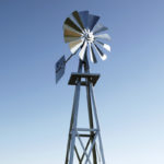 A windmill head against a blue sky.