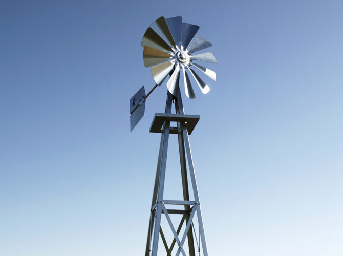 A windmill head against a blue sky.