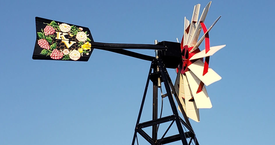 Upper area of a black windmill tower. The head is red and white. The tail is black with 